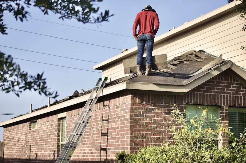 Professional roofer working on a residential roof in Easterwood Field